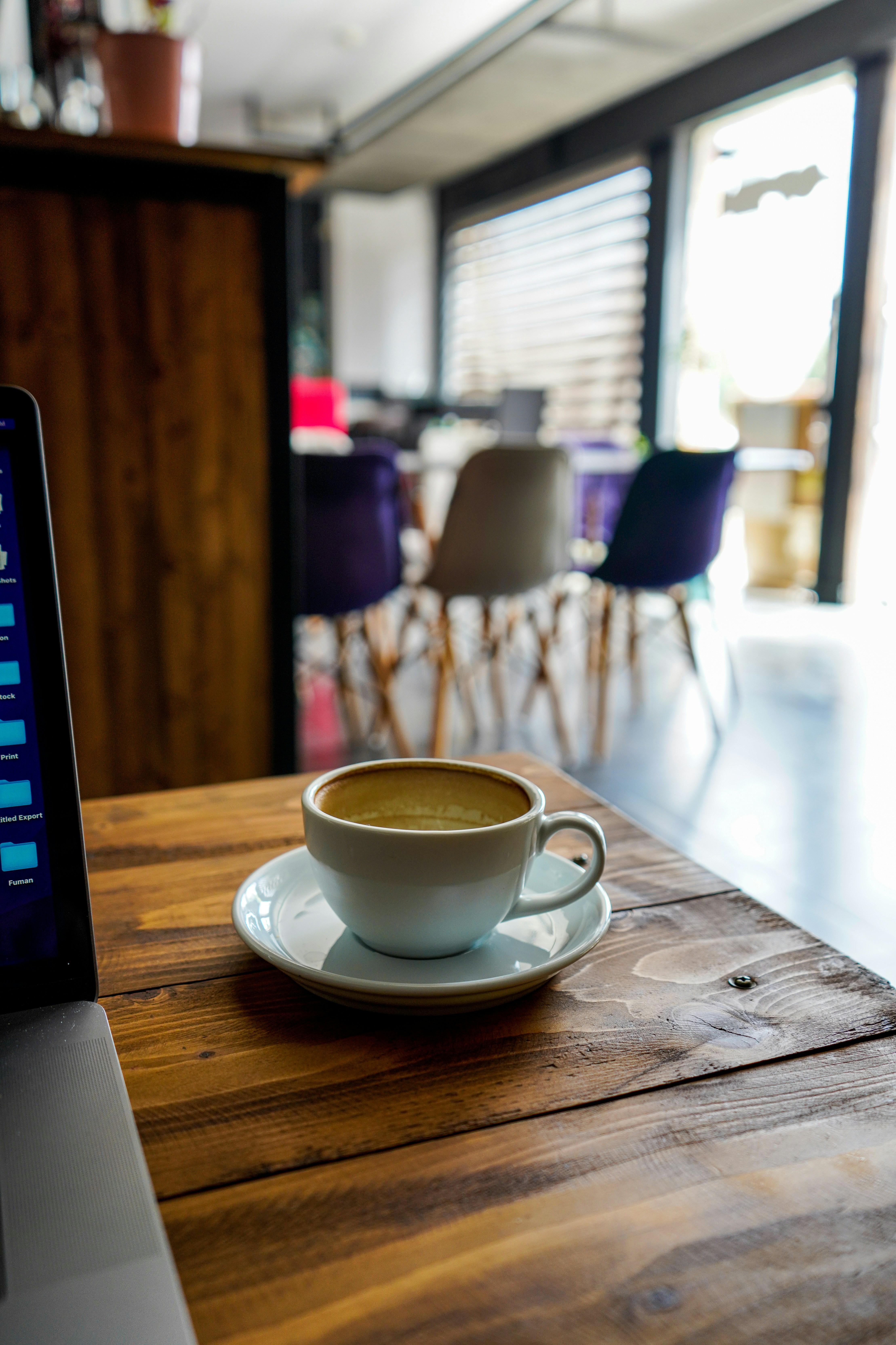 Outdoor terrace with laptop, coffee, and Brussels streetscape.